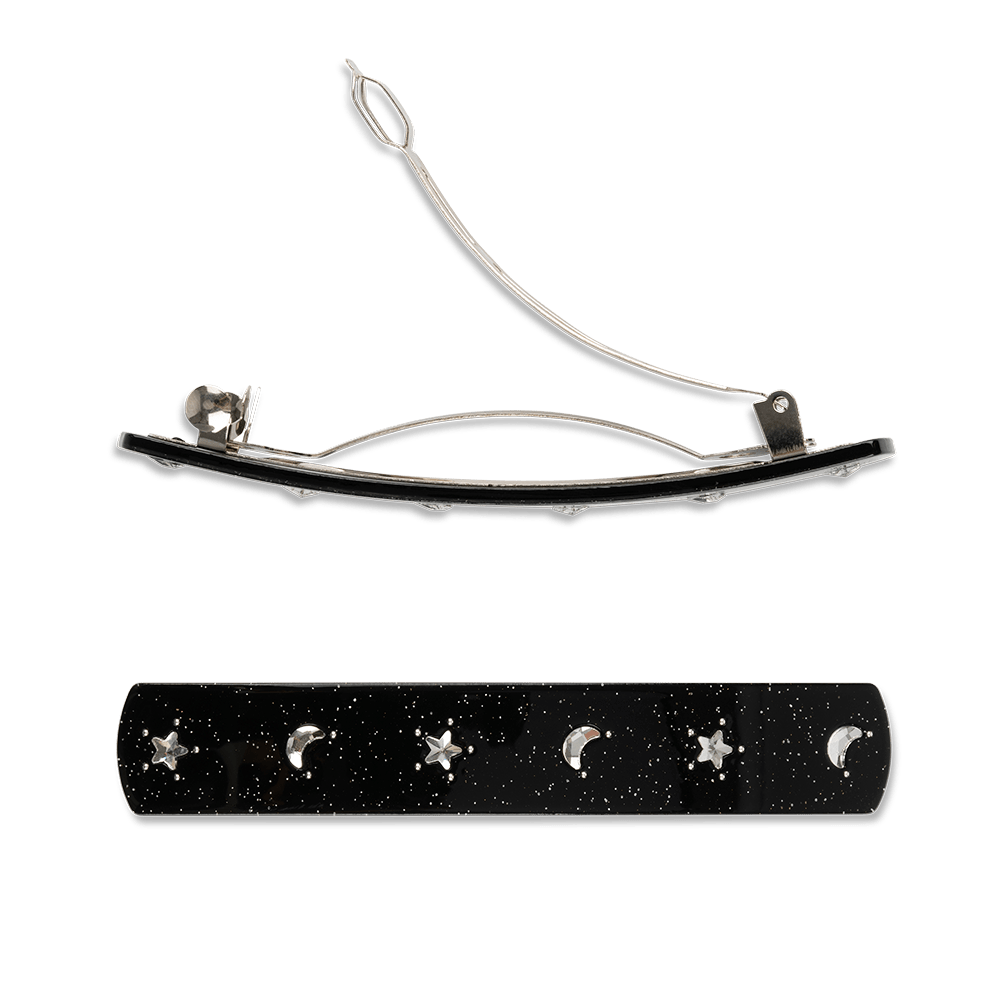Sort hårspænde med sølvfarvede måner og stjerner samt glitrende detaljer, set forfra og fra siden