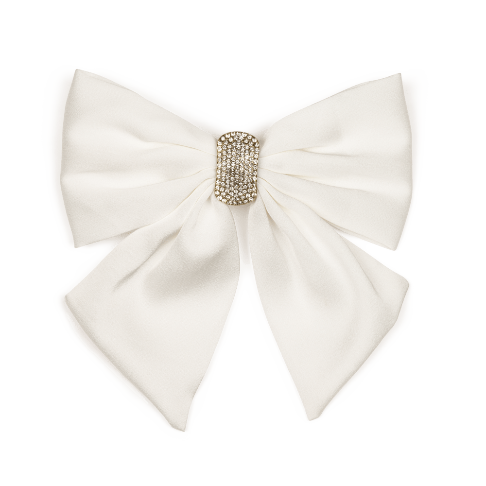 Hårspænde med stor hvid sløjfe og skinnende krystalsten. En elegant detalje, der tilfører din frisure et romantisk og stilfuldt udtryk.