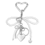 Pearly Bow Bag Charm – taskevedhæng med en elegant sløjfe af hvide perler og et hjertevedhæng i sølv.