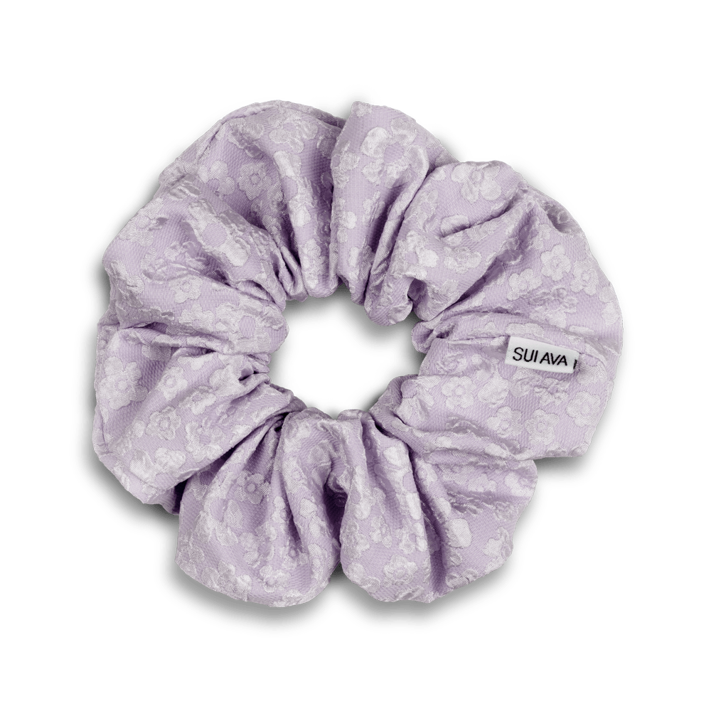 Blossom Scrunchie i lilla – Elegant scrunchie med blomsterdetaljer i en delikat lilla nuance.