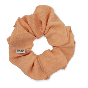 Ea Zig-Zag Scrunchie i orange er en blød og elastisk scrunchie i en varm, energisk nuance. Perfekt til en skånsom frisure eller som et dekorativt armbånd.