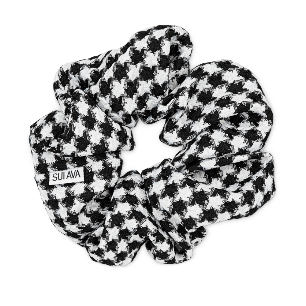 Sort og hvid pied-de-poule mønstret Pop Scrunchie håraccessory lavet i blødt polyesterstof.