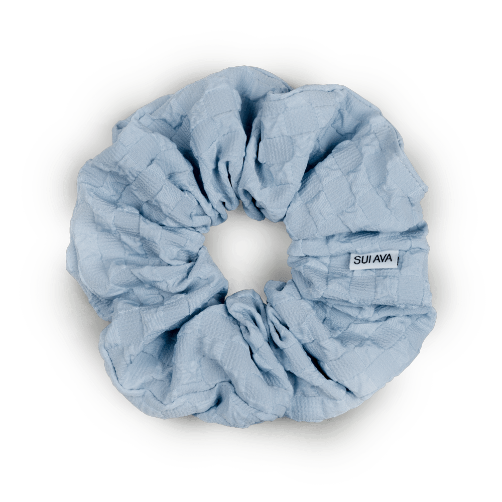 Daydream Scrunchie i lyseblå – blød og elastisk scrunchie i en let og elegant nuance, perfekt til skånsomme frisurer.